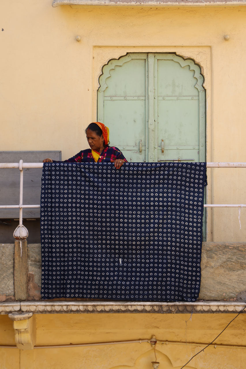 Jaipur artisan woman with hand block printed indigo fabric — ethical fashion by Daughters of India